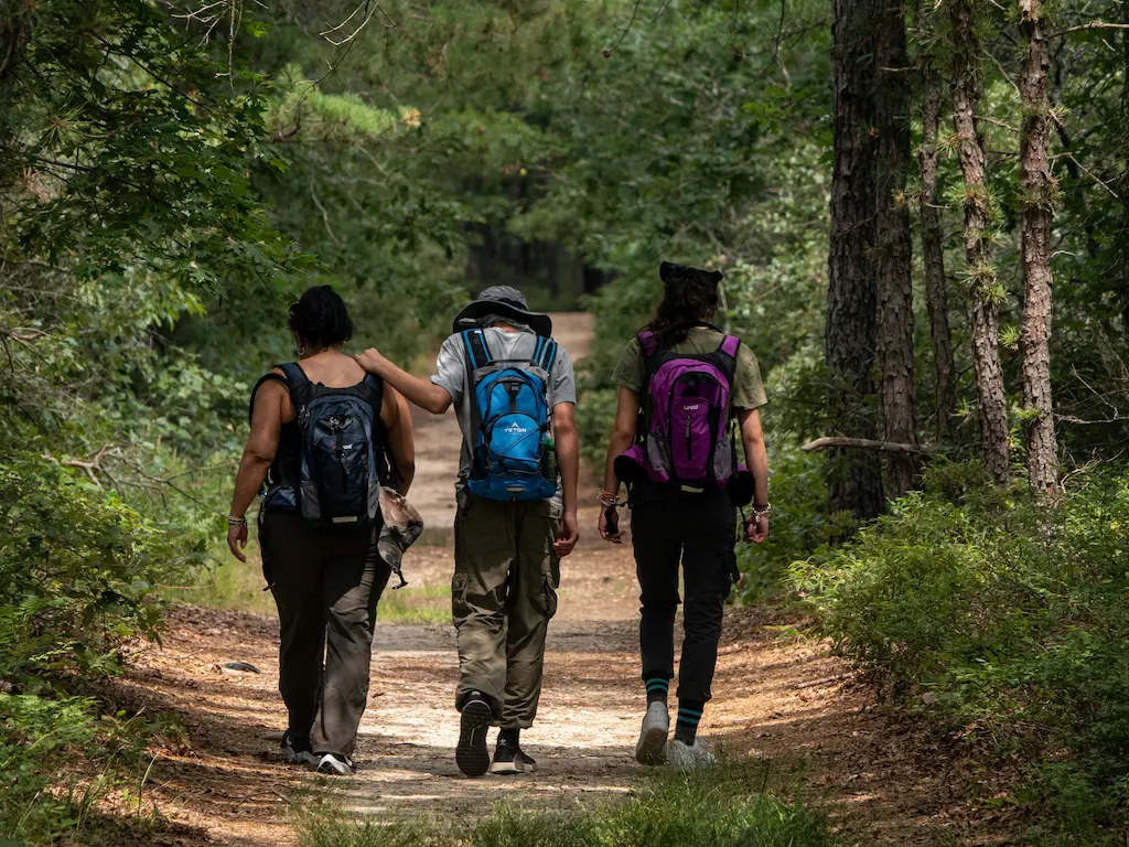three people walking along a trail